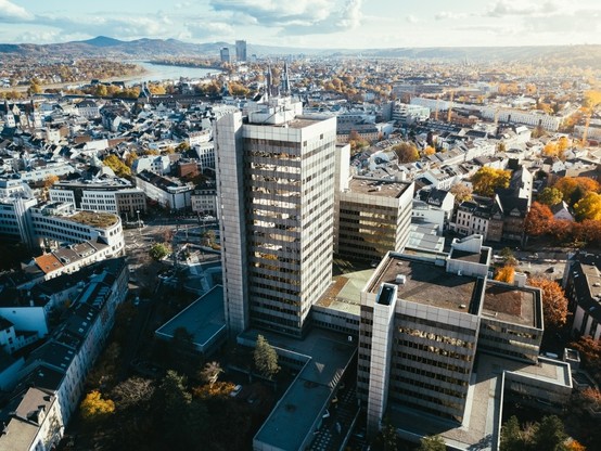 Luftbild des Bonner Stadthauses mit der Innenstadt und dem Siebengebirge im Hintergrund.