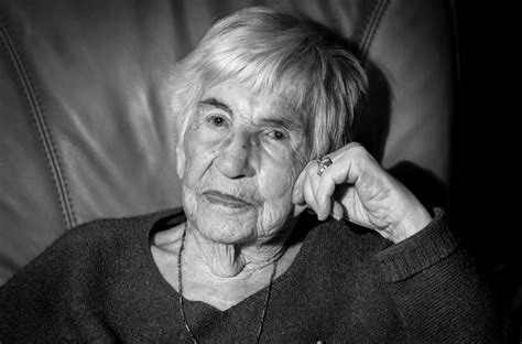 Ein schwarz-weiß Foto einer älteren Dame in eine m Sessel.