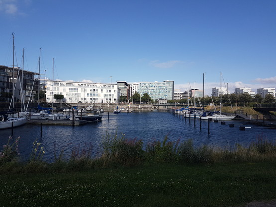 View to a small habour for small ships. In the background houses with flats.