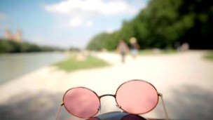 Brille mit Rosa Gläsern liegt auf dem Boden